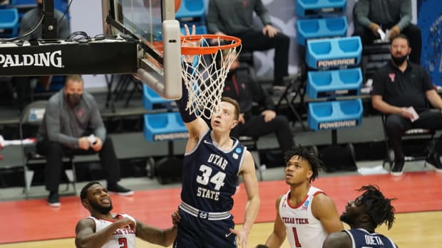 Mar 19, 2021; Bloomington, Indiana, USA; Utah State Aggies forward Justin Bean (34) shoots against Texas Tech Red Raiders guard Jamarius Burton (2) and guard Terrence Shannon Jr. (1) during the first half in the first round of the 2021 NCAA Tournament at Simon Skjodt Assembly Hall. Mandatory Credit: Robert Goddin-USA TODAY Sports